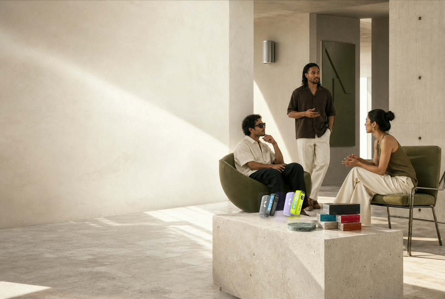 Three adult creative professionals in a sunlit contemporary gallery with represented heating devices and consumables displayed on a stone table